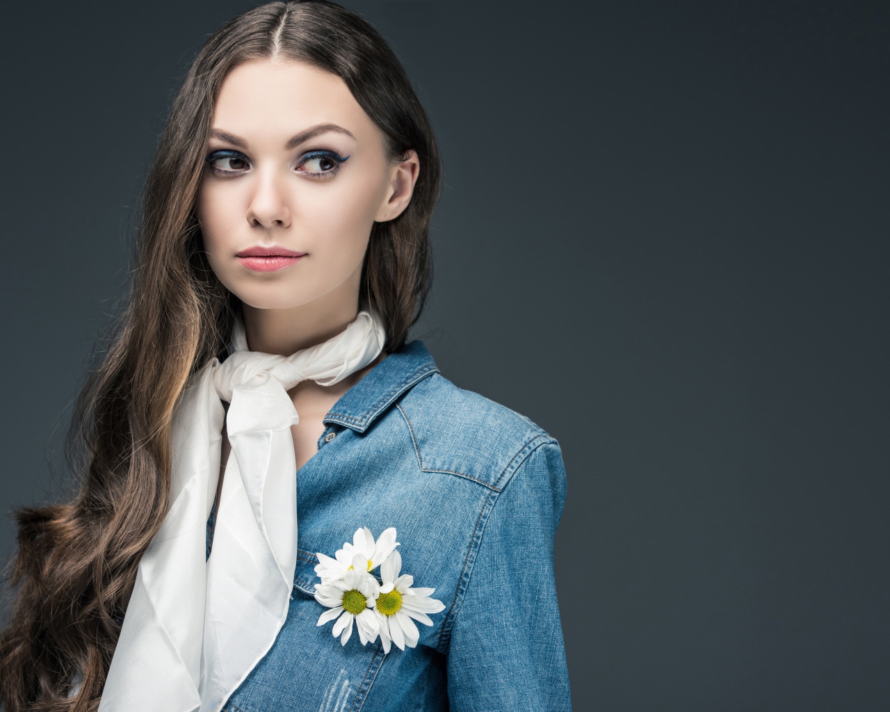 Красивая девушка в джинсовой куртке с шарфом на шее 