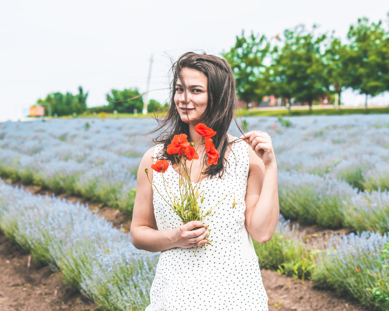 Красивая девушка в платье с букетом маков