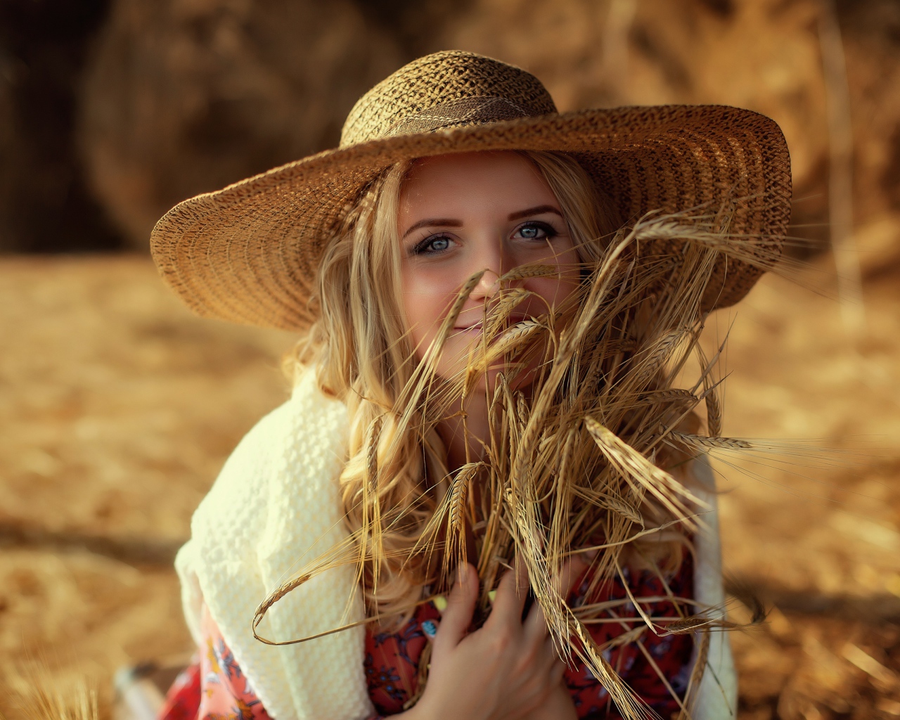 Красивая девушка в шляпе с колосьями в руке