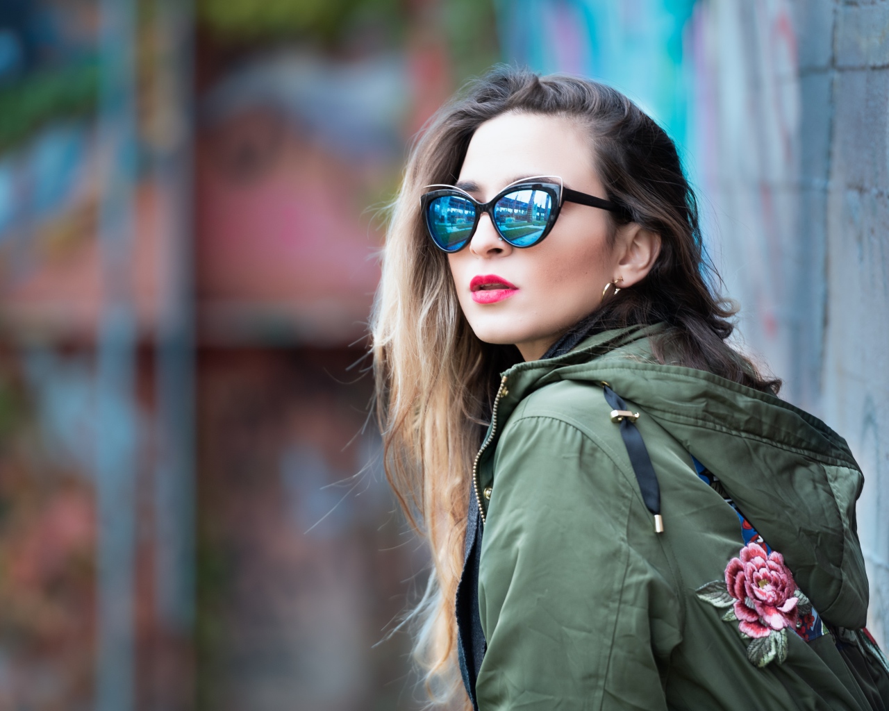 Красивая девушка в куртке и солнечных очках