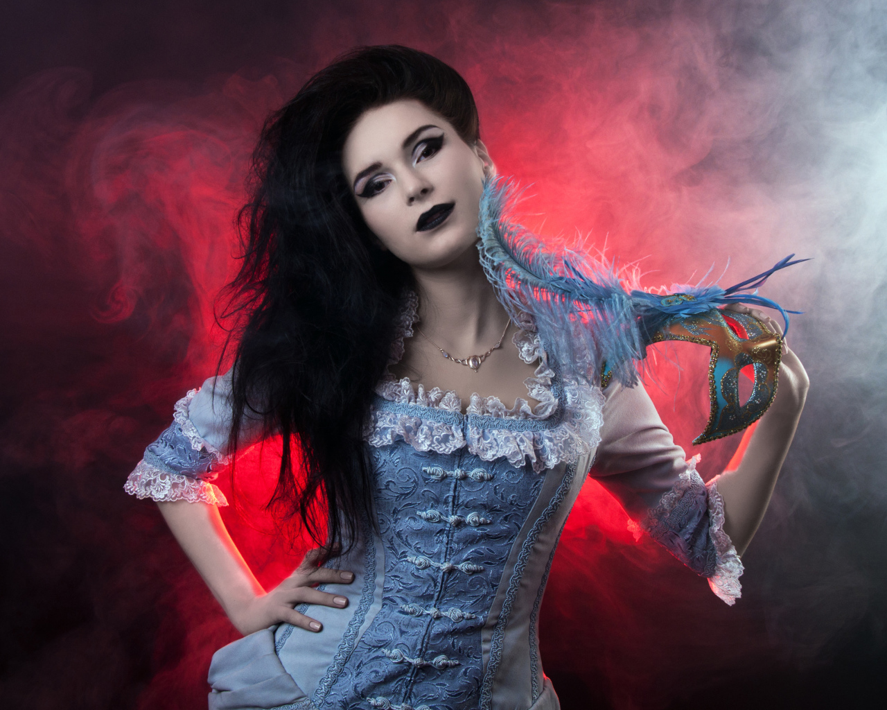 Красивая девушка в старинном платье с маской в руке
