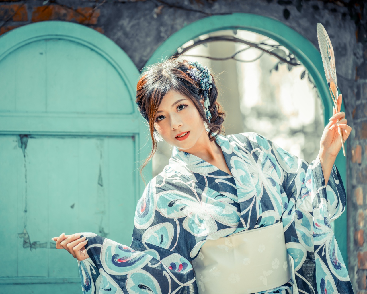 Красивая девушка в кимоно с веером в руке