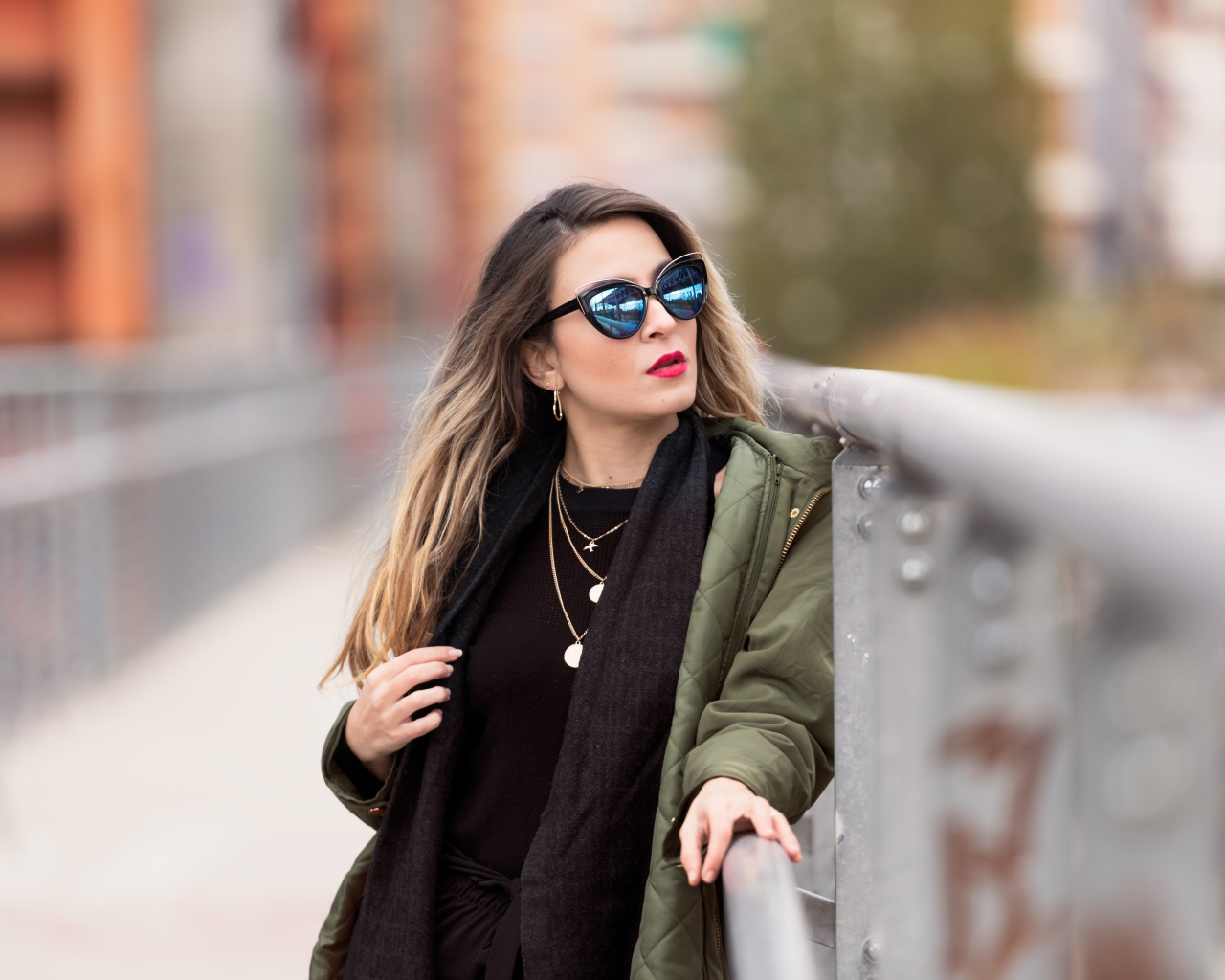 Красивая девушка в солнечных очках на мосту