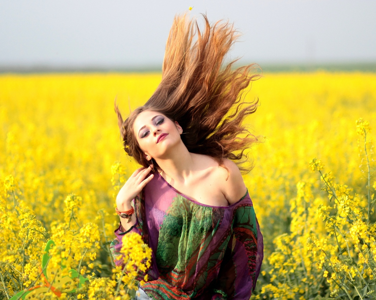 Красивая девушка на поле с желтыми цветами