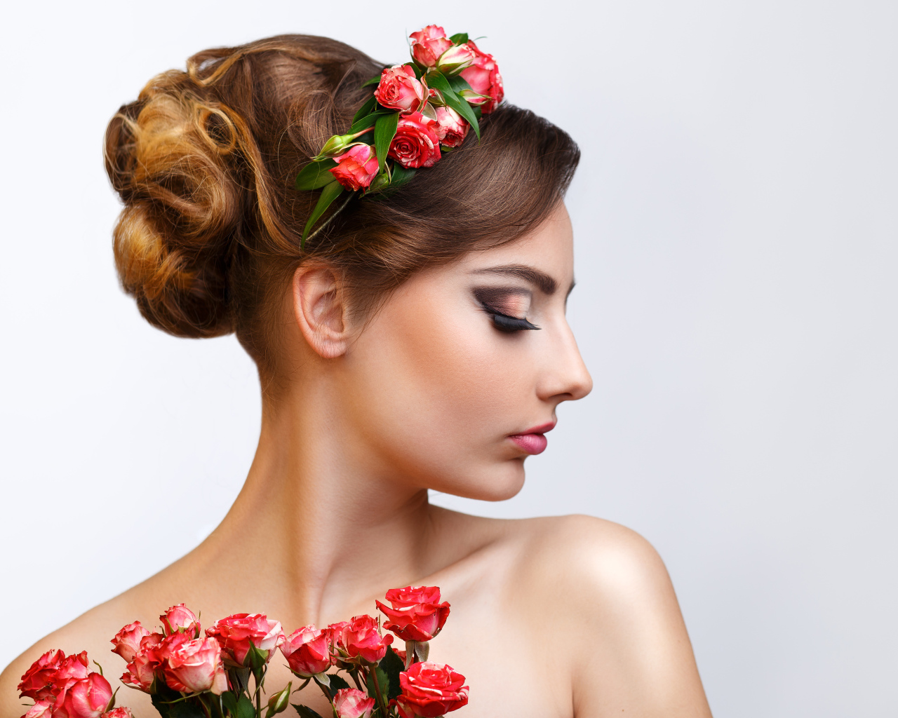 Красивая девушка с прической и венком из роз в волосах 