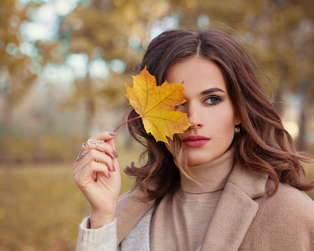 Красивая девушка с осенним листом в руке