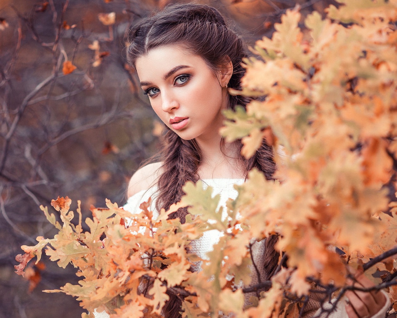 Красивая девушка с косами на фоне желтых листьев 