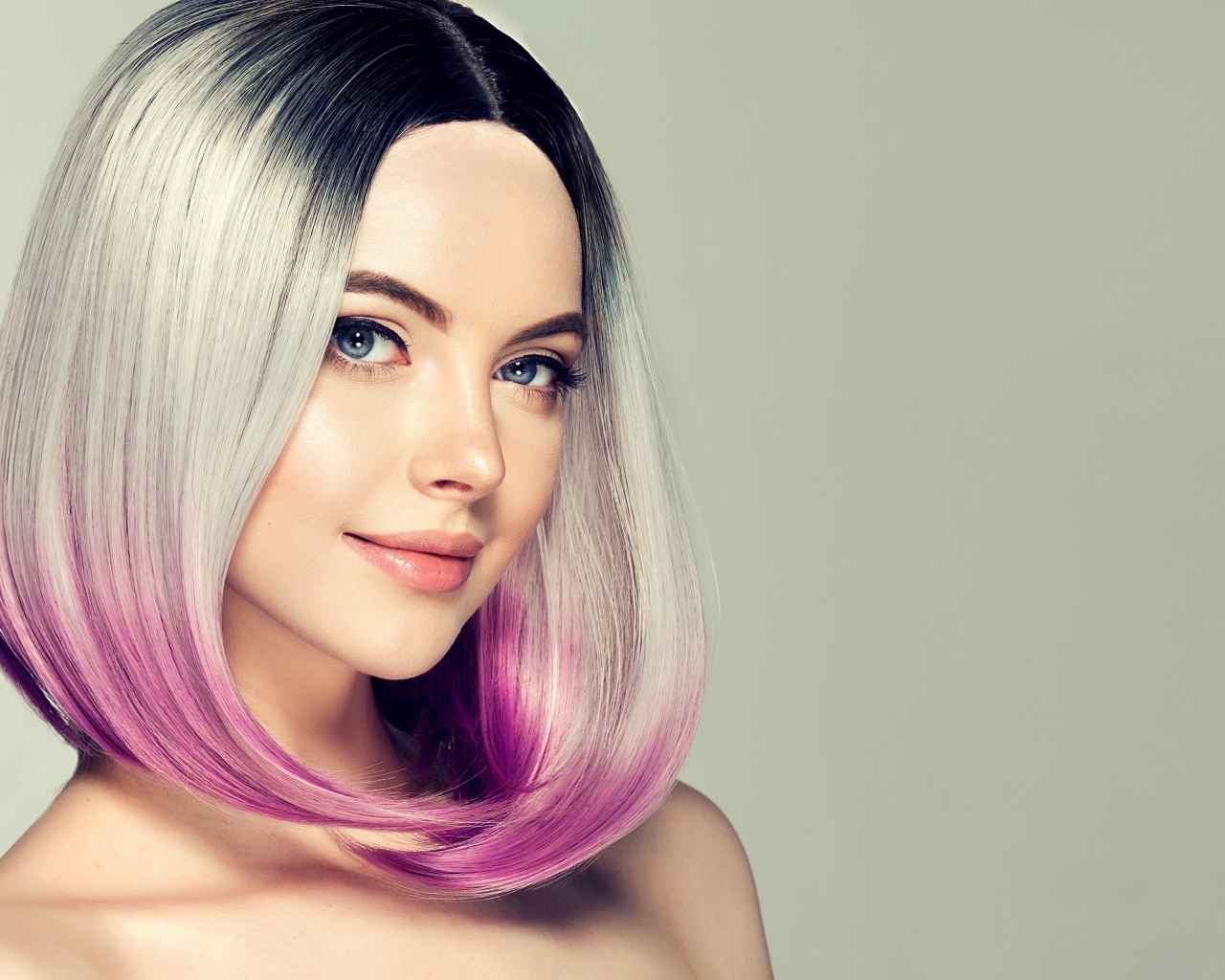 Красивая девушка с крашеными волосами на сером фоне