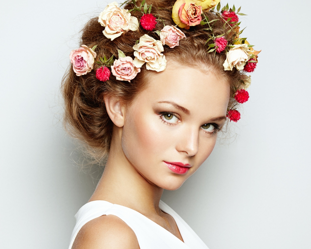 Красивая девушка с цветами в волосах на сером фоне