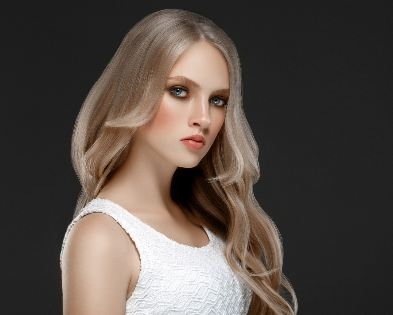 Красивая девушка с длинными  белыми волосами на сером фоне