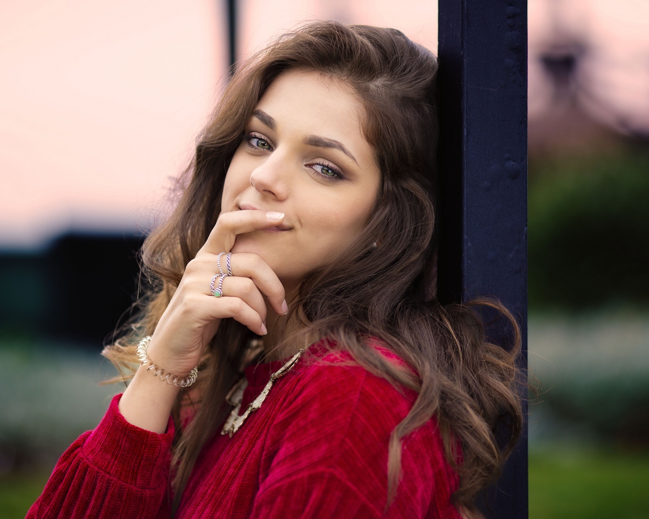 Красивая длинноволосая шатенка с рукой у лица