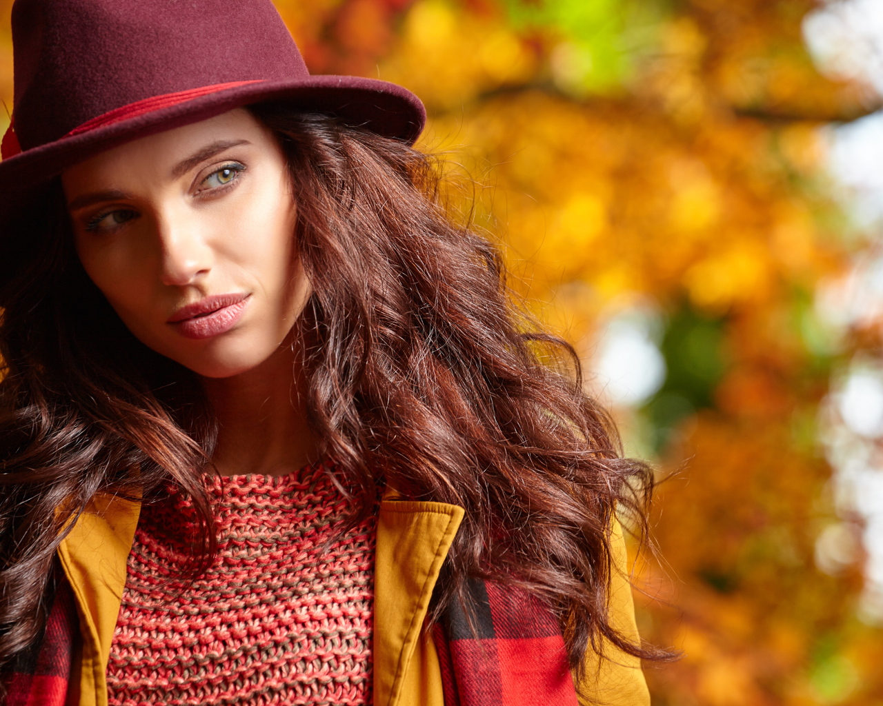 Красивая длинноволосая девушка в шляпе осенью