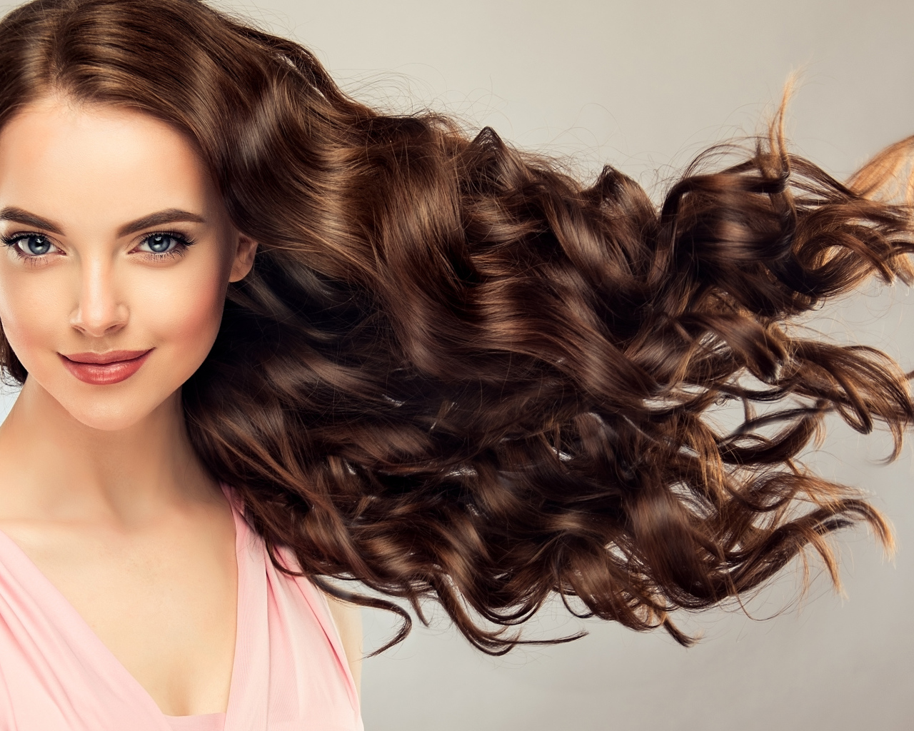 Красивые длинные волосы у девушки на сером фоне