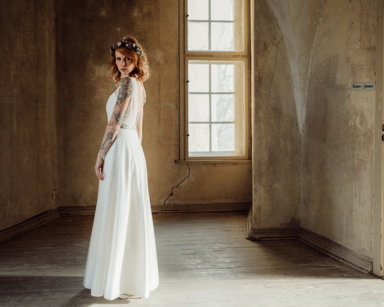 Красивая рыжеволосая девушка в белом платье с  татуировками на теле 