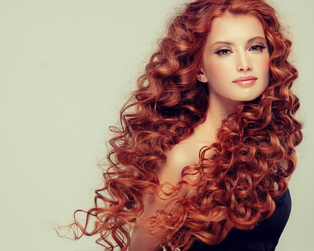 Красивая рыжеволосая девушка на сером фоне