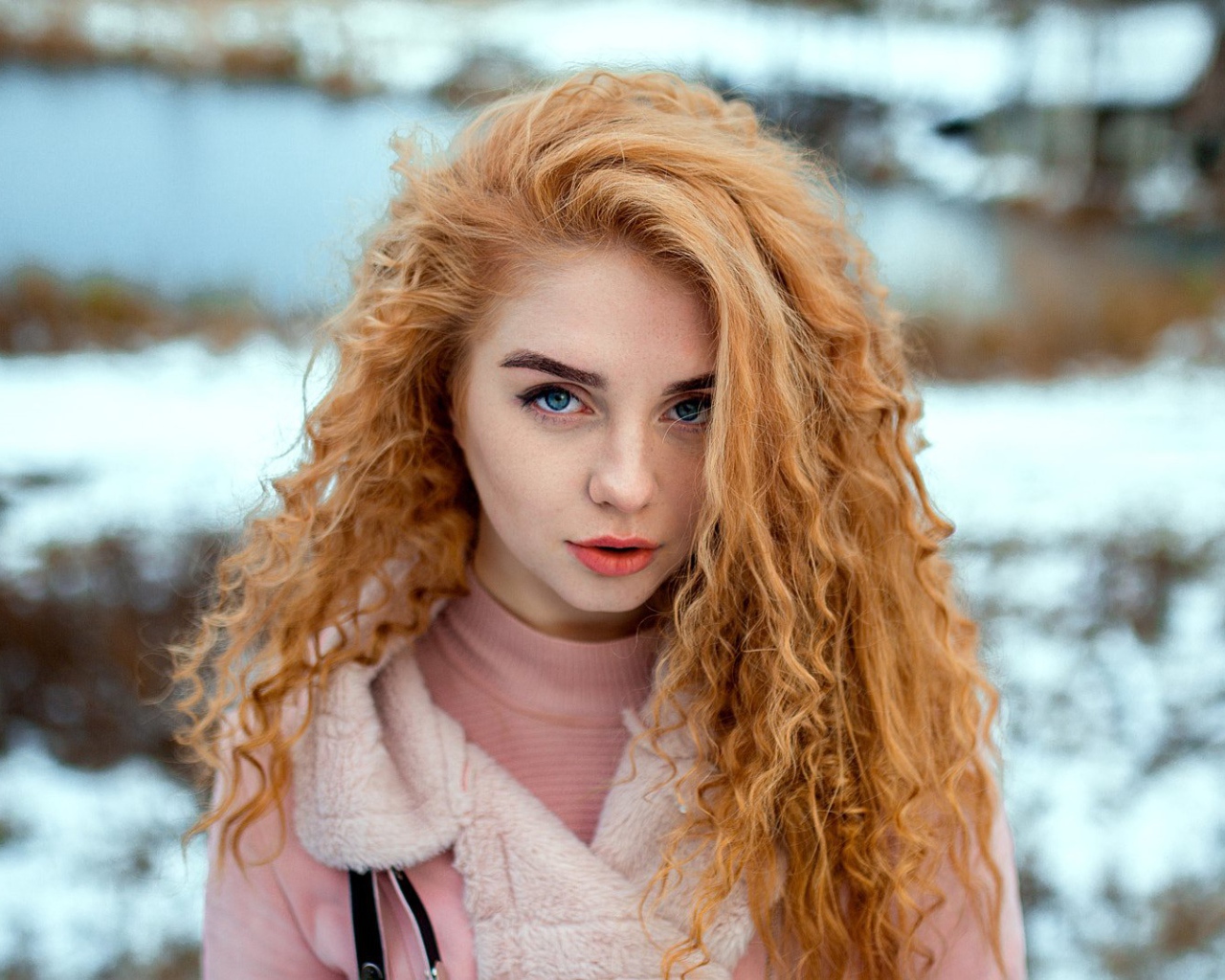 Красивая рыжеволосая девушка с голубыми глазами зимой