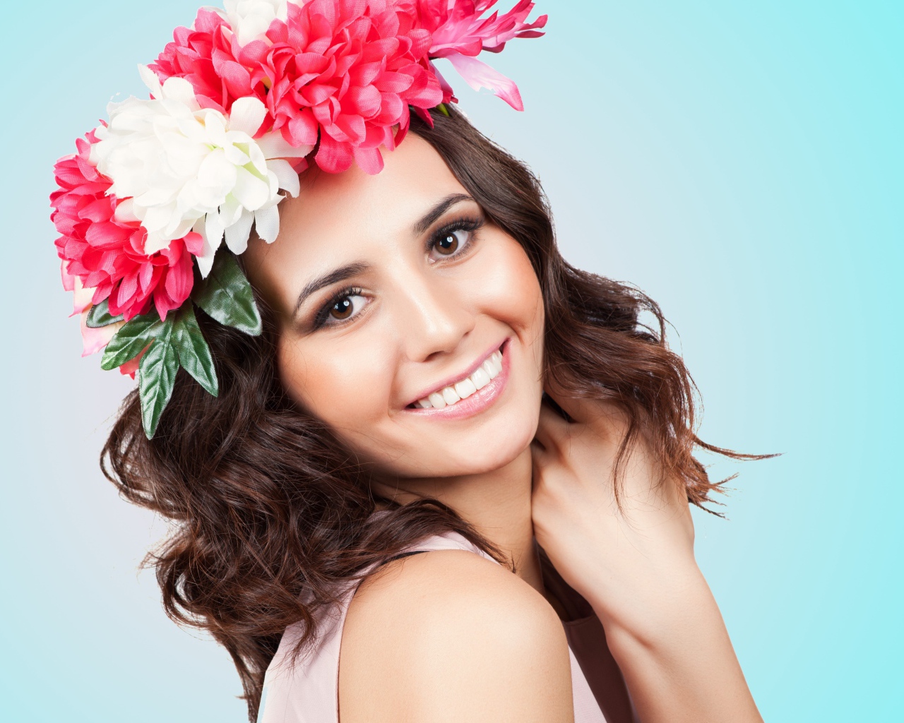 Красивая улыбающаяся девушка с венком на голове на голубом фоне