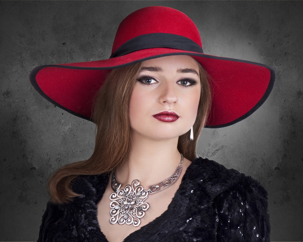 Красивая стильная девушка в красной шляпе с украшением на шее 
