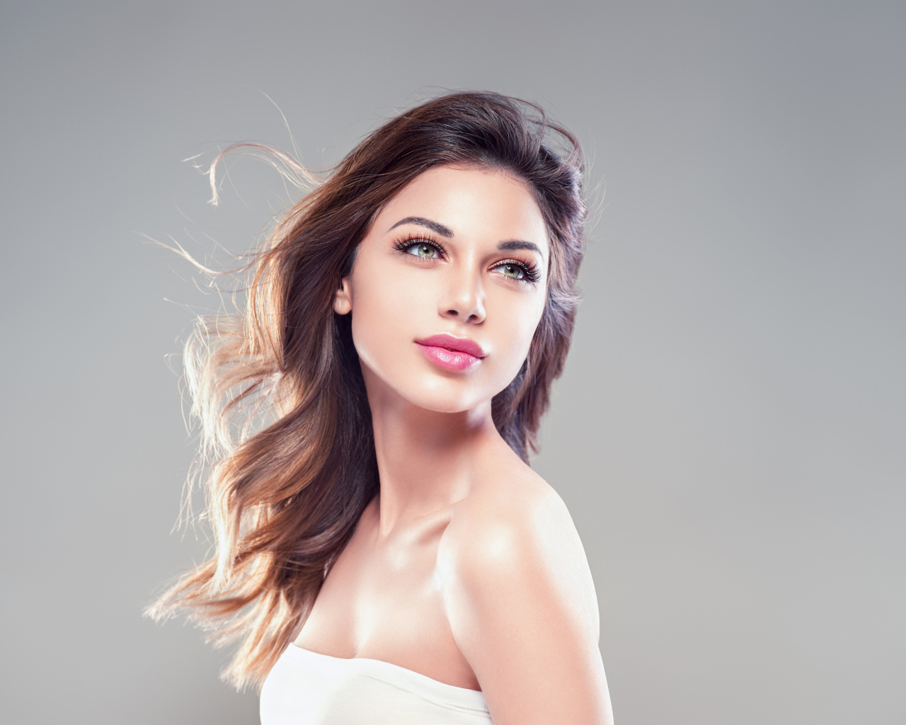 Красивая нежная девушка шатенка на сером фоне