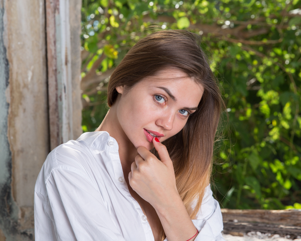 Красивая нежная девушка с серыми глазами с пальцем у рта