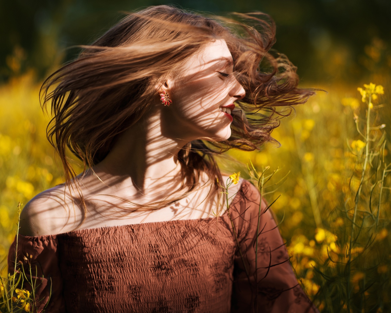 Красивая молодая девушка на поле с желтыми цветами