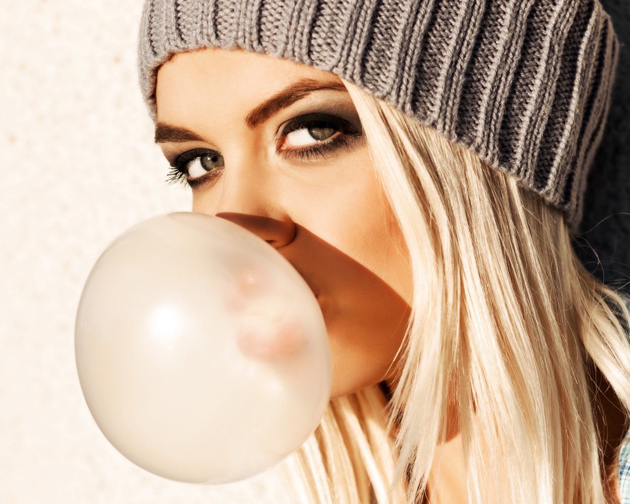 Девушка блондинка с жвачкой во рту крупным планом