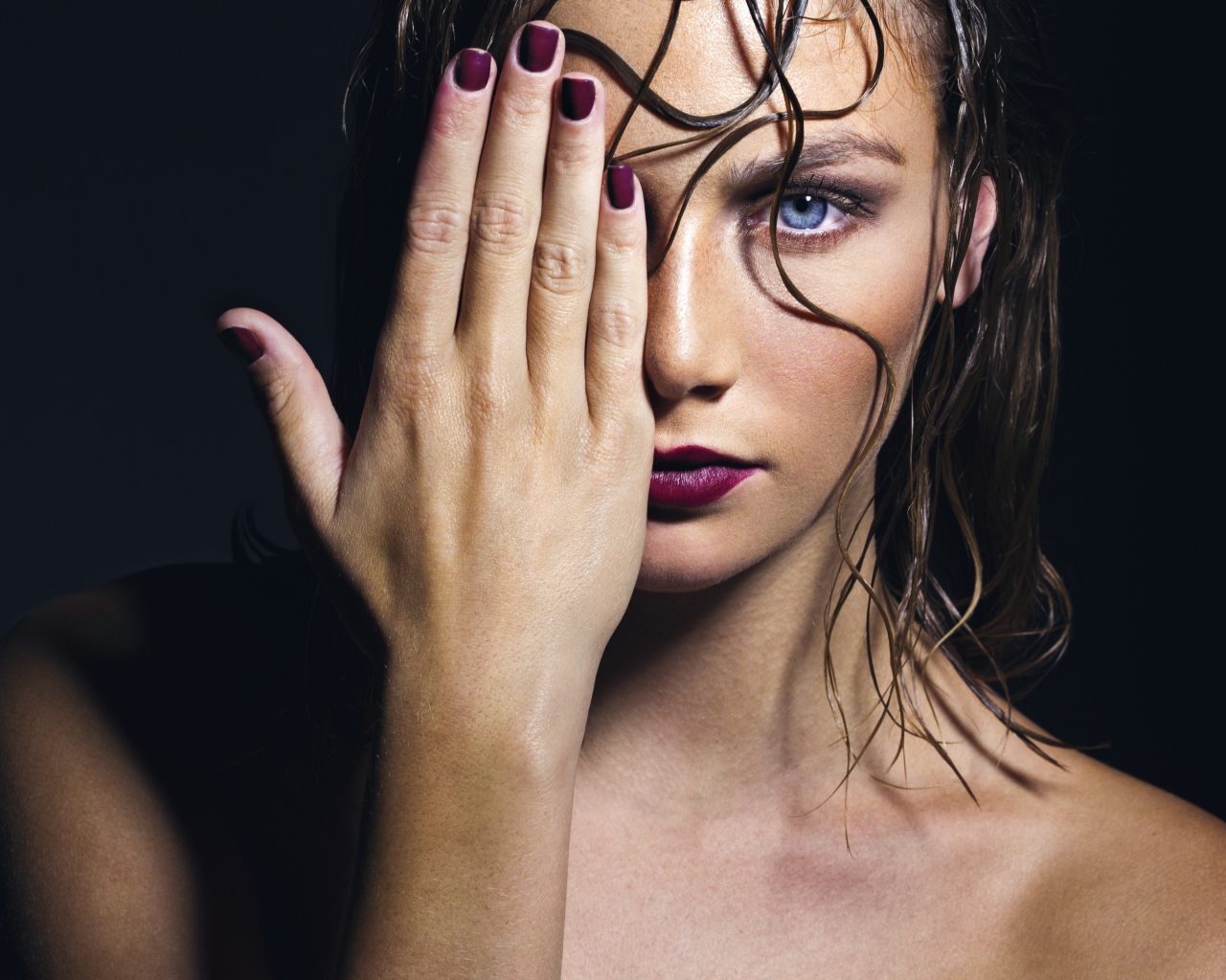 Голубоглазая девушка закрывает лицо рукой