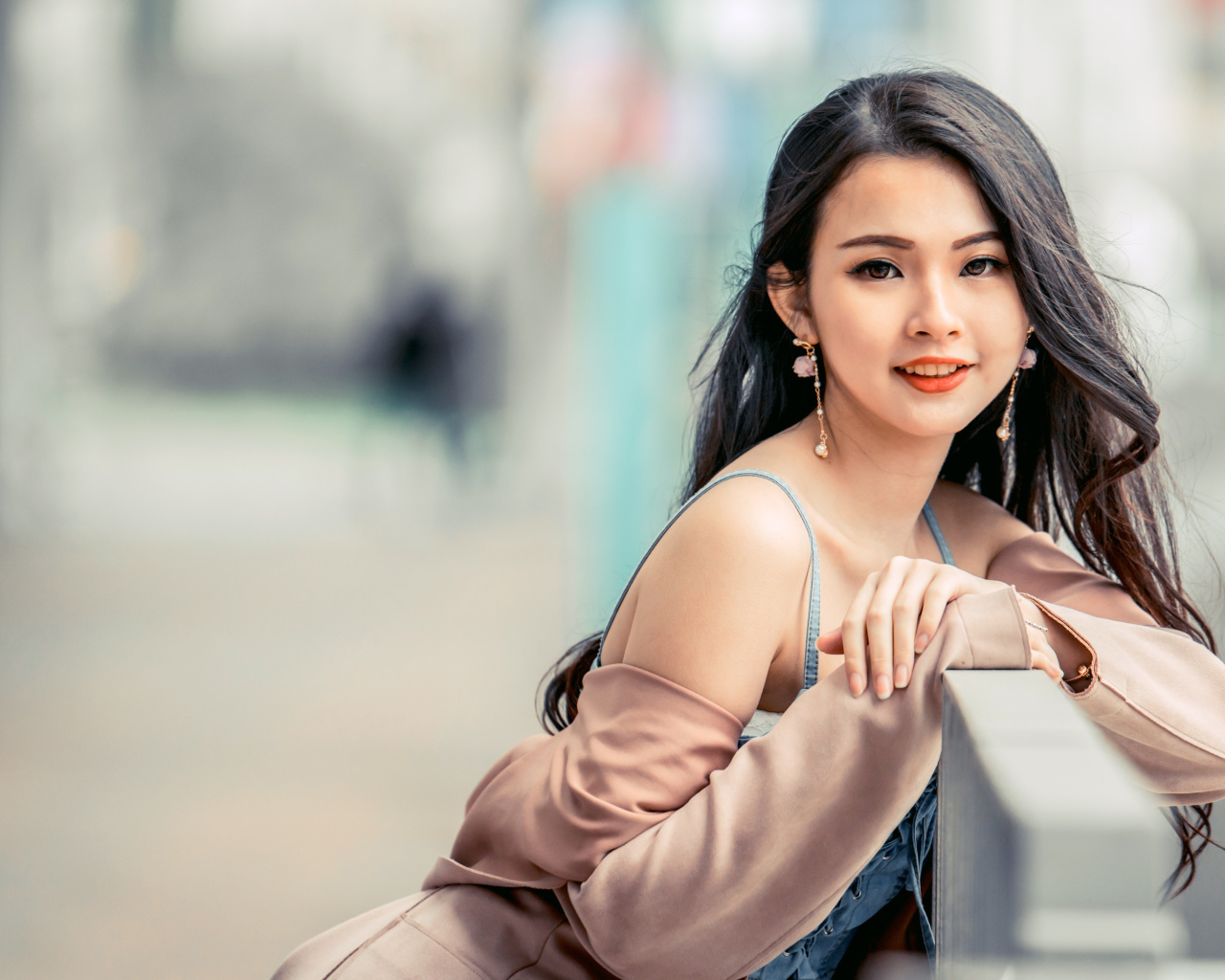 Очаровательная девушка азиатка сидит на лавке