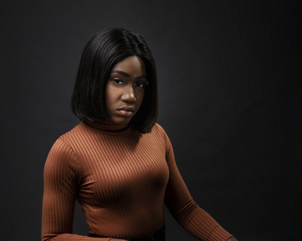 Темнокожая девушка с короткой стрижкой на сером фоне