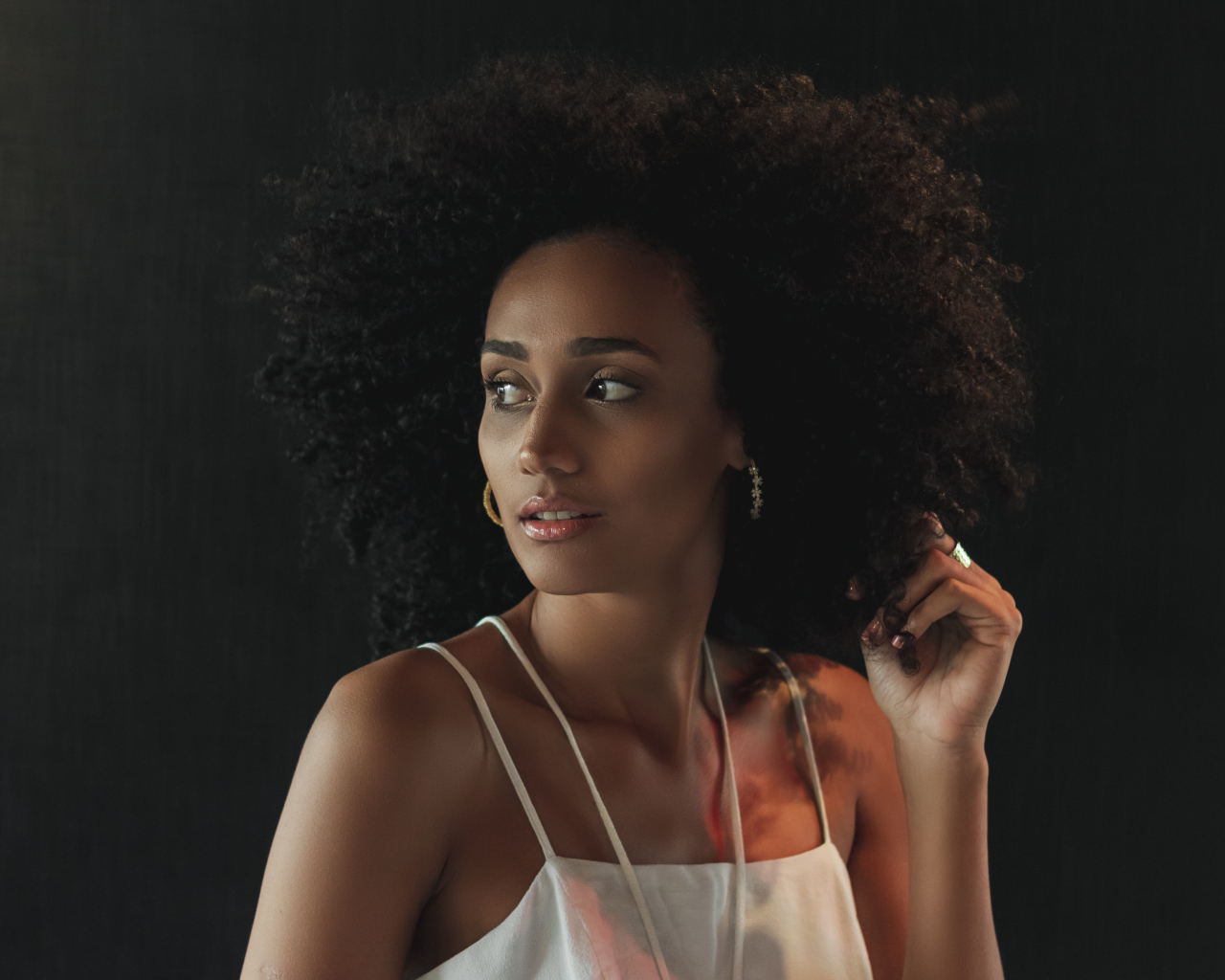 Темнокожая девушка с красивыми волосами на сером фоне