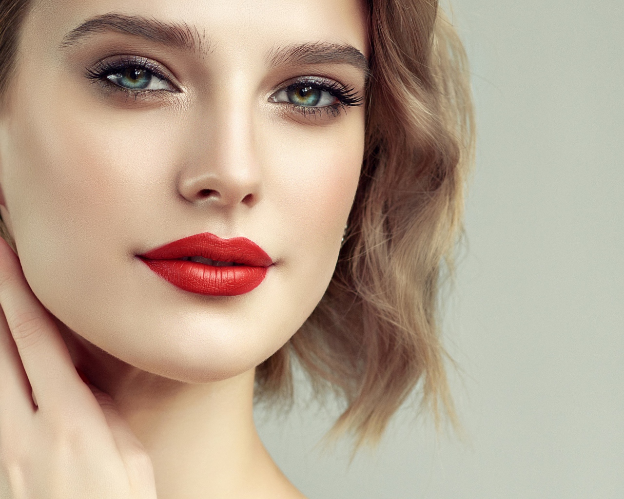 Лицо девушка с красивым макияжем на сером фоне