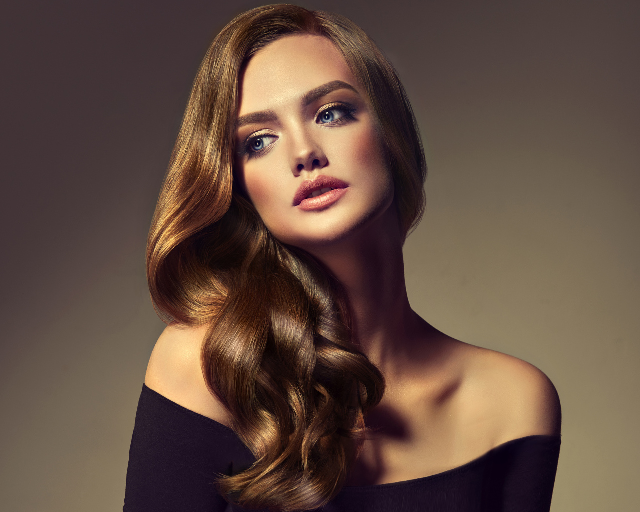 Нежная голубоглазая модель с длинными волосами на сером фоне