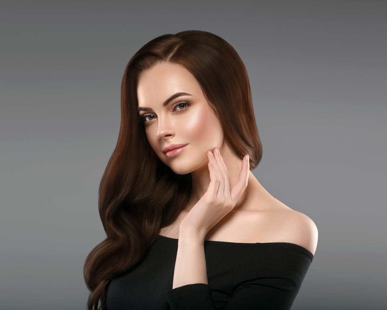 Нежная длинноволосая шатенка в черном платье на сером фоне