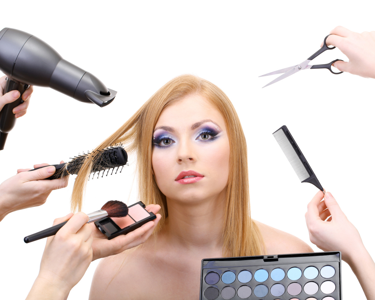 Девушке делают макияж и прическу на белом фоне