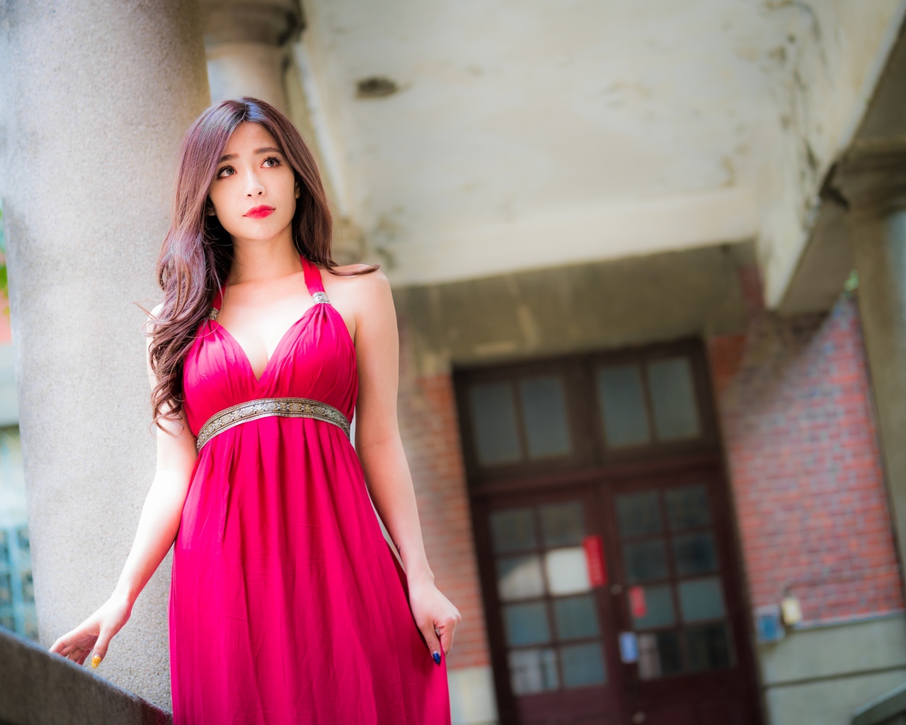Девушка в красивом розовом платье у здания