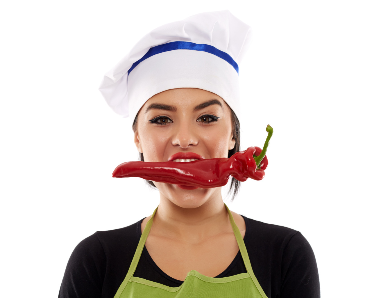 Девушка в шапке повара с красным перцем во рту на белом фоне