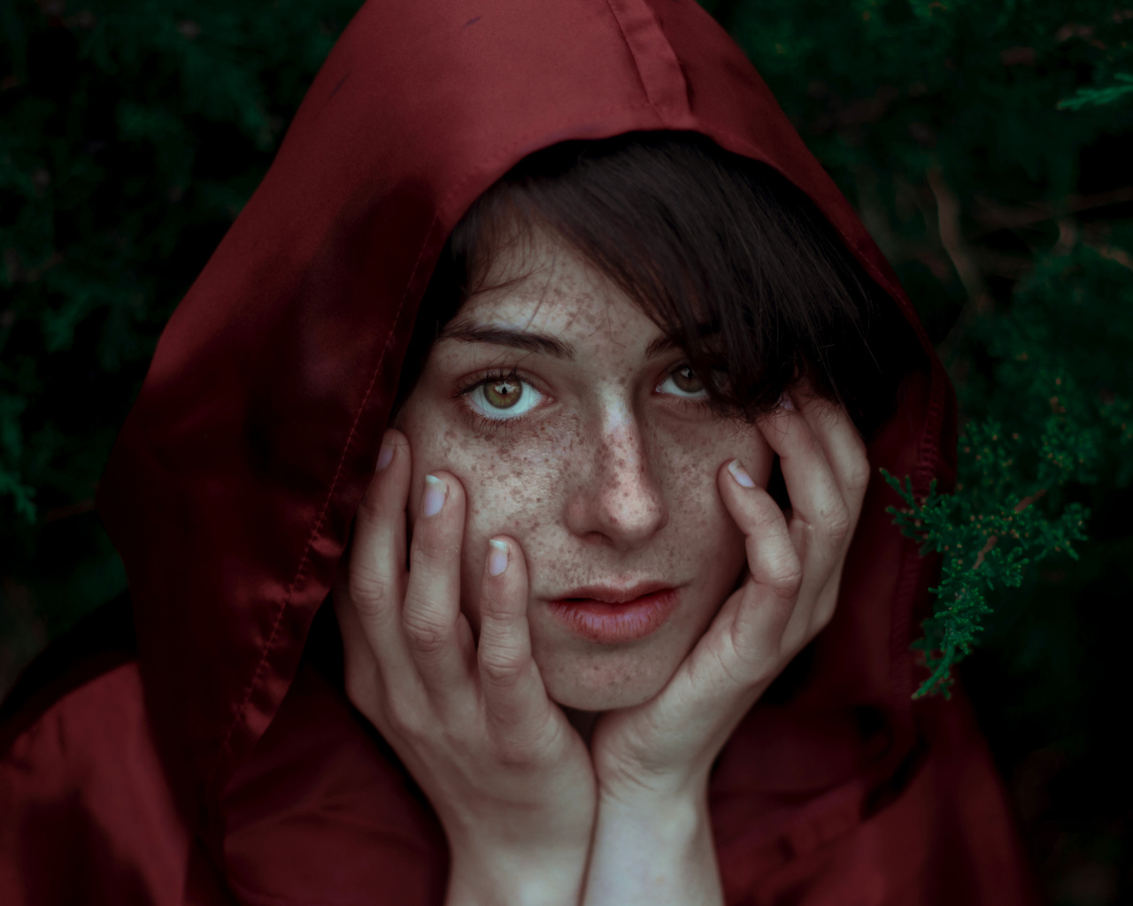 Девушка в красном плаще с веснушками на лице