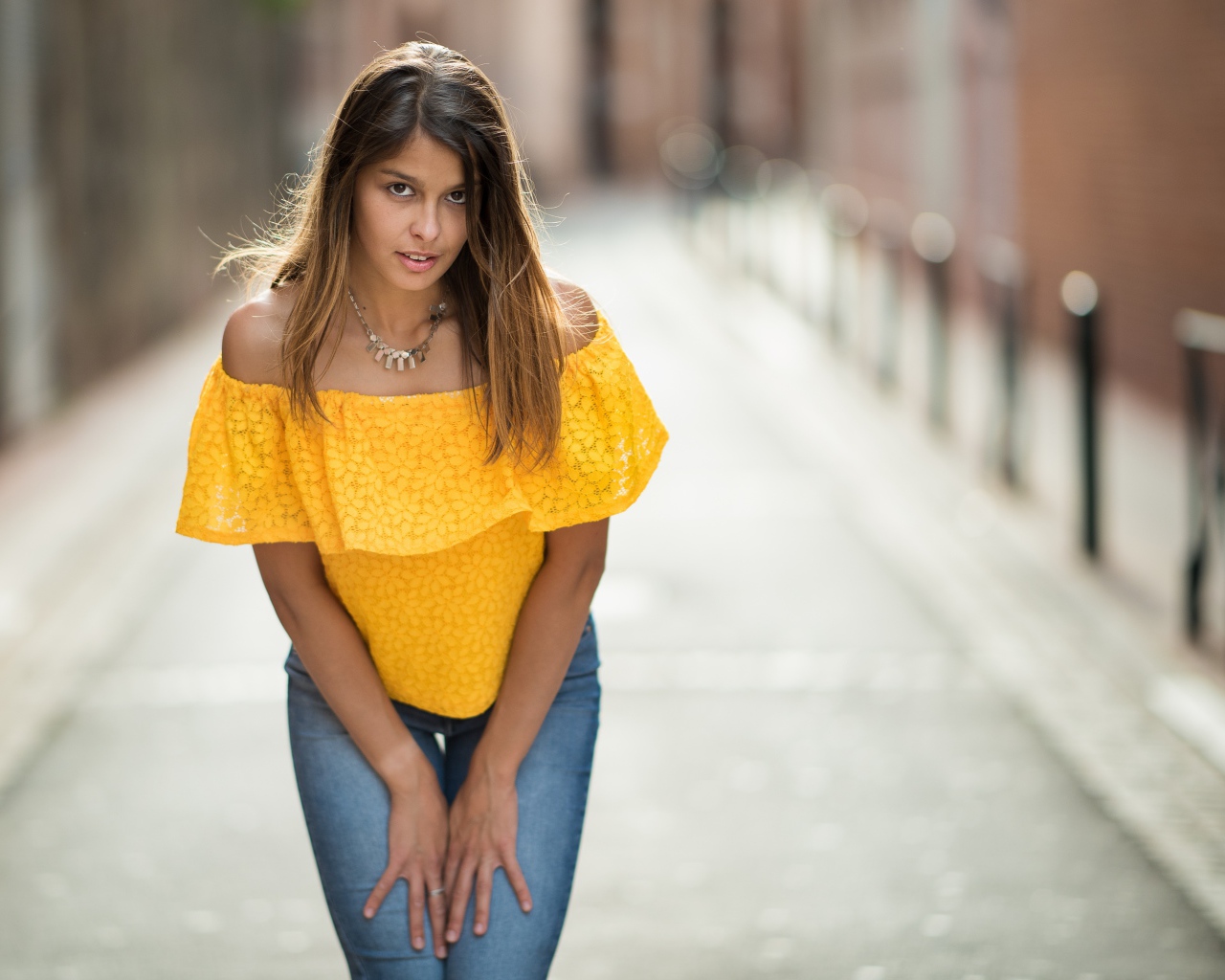 Девушка в джинсах стоит на улице 