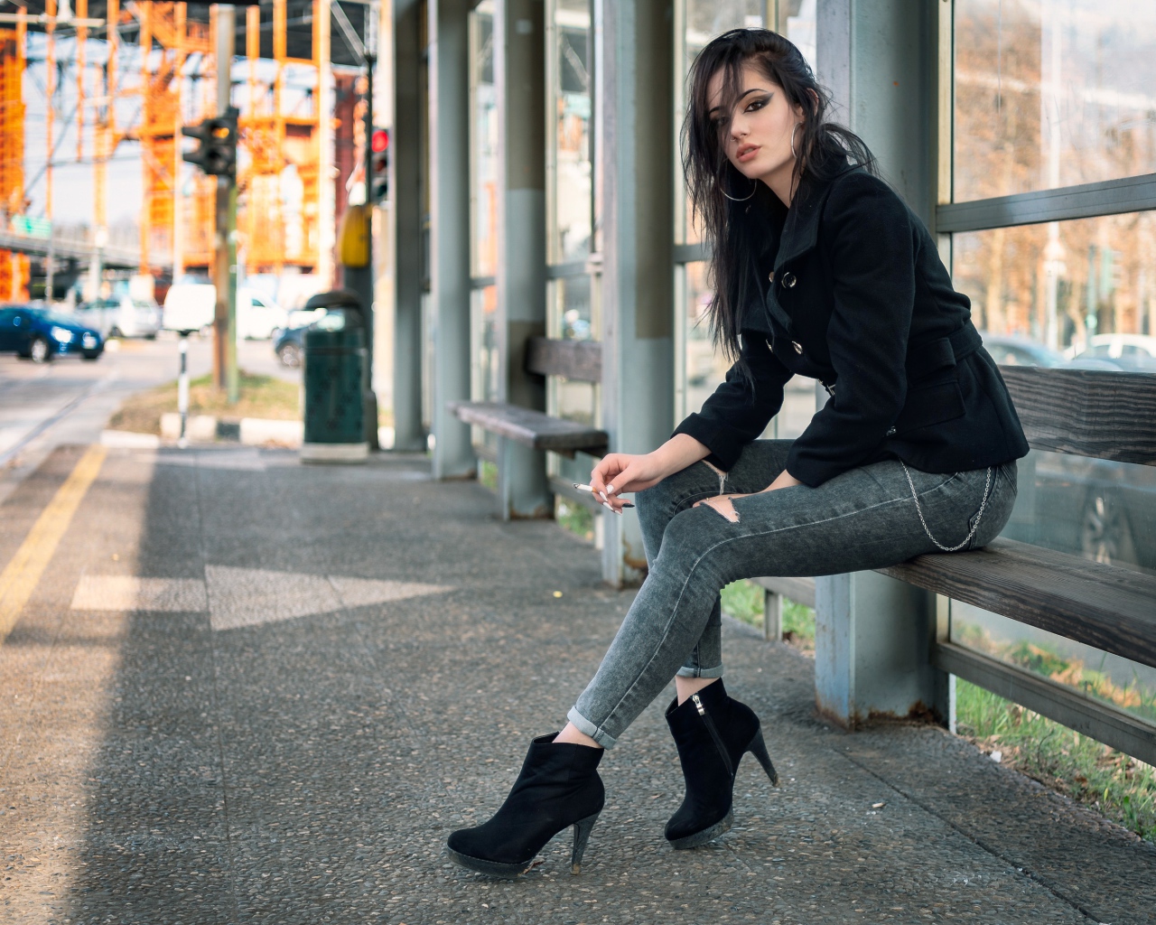Девушка неформалка сидит на автобусной остановке