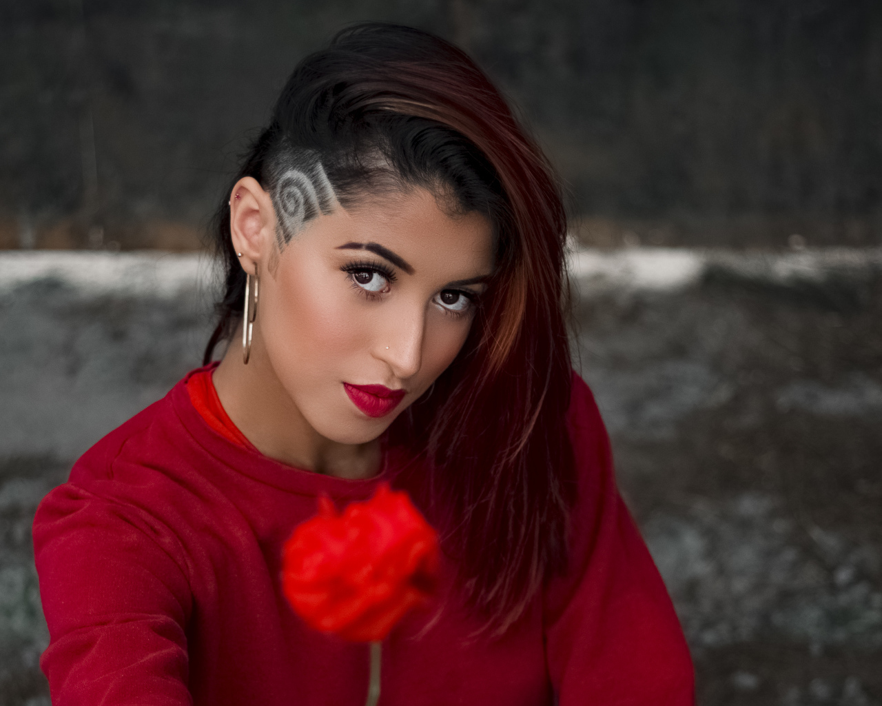 Девушка со стрижкой держит розу в руке