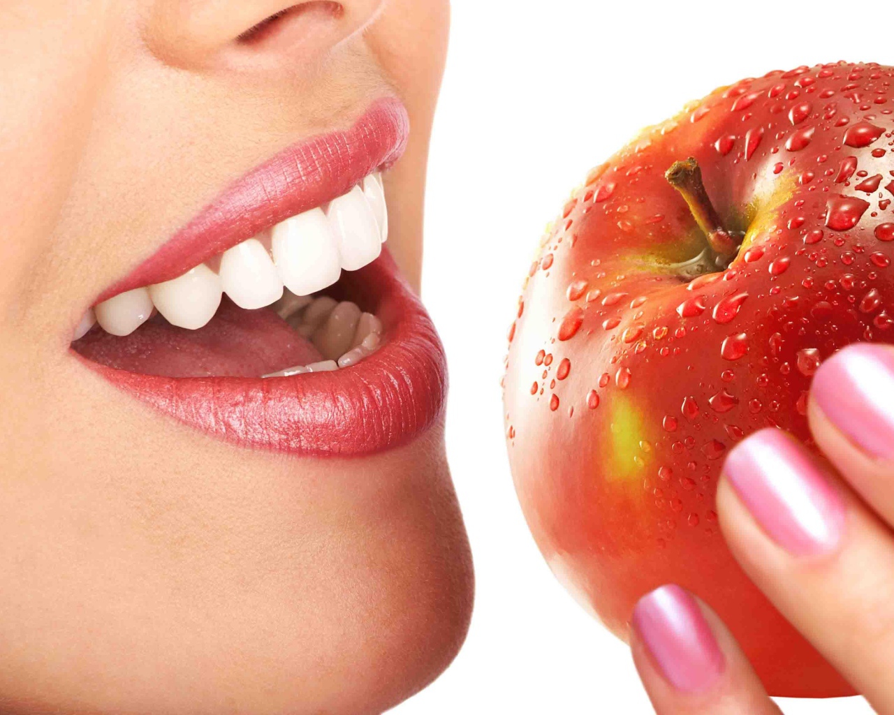 Девушка с красивыми белыми зубами кусает яблоко