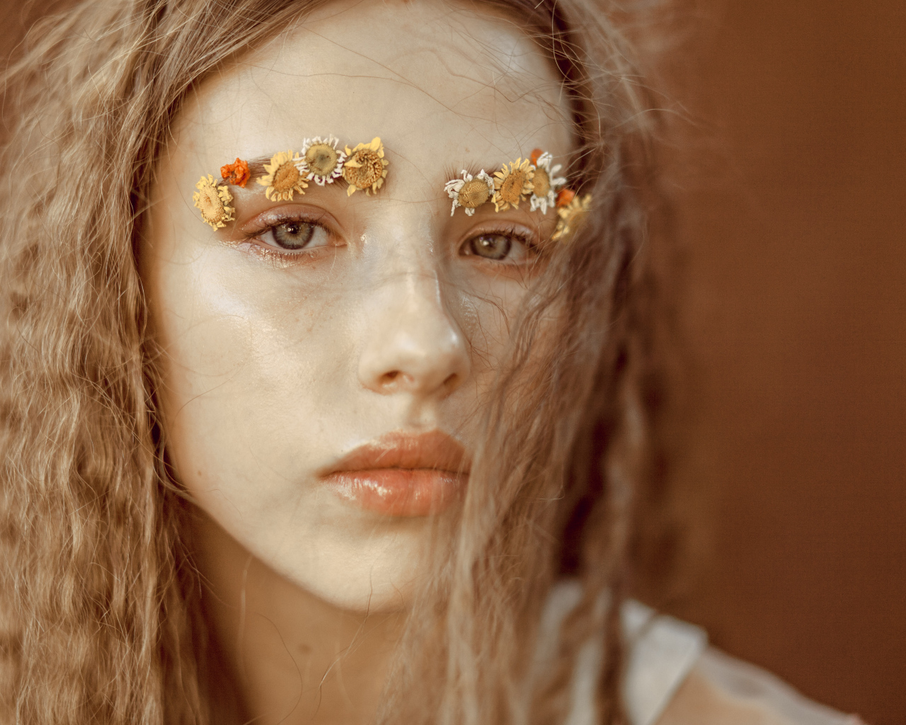 Девушка с цветами на бровях крупным планом
