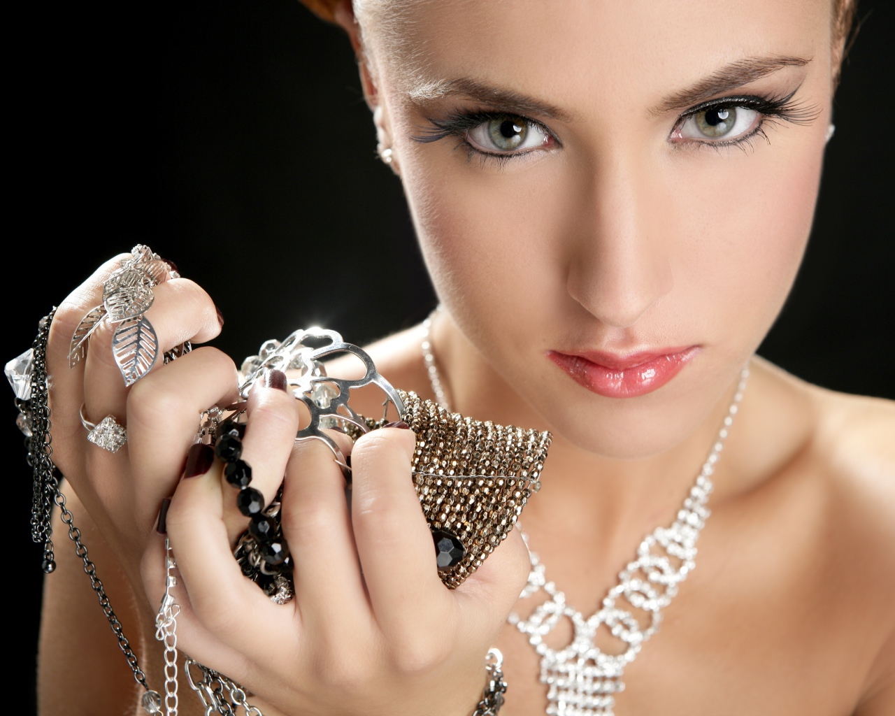 Девушка с длинными ресницами держит драгоценности в руке