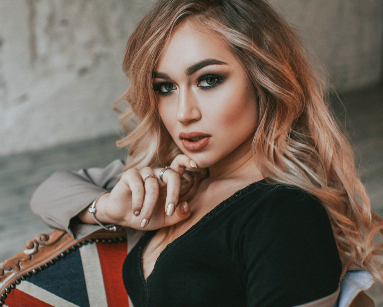 Горячая девушка с макияжем сидит на стуле