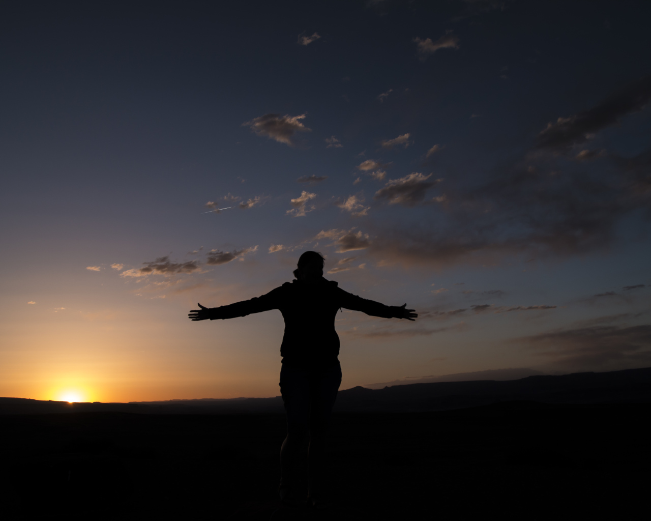 Силуэт девушки на фоне неба на закате