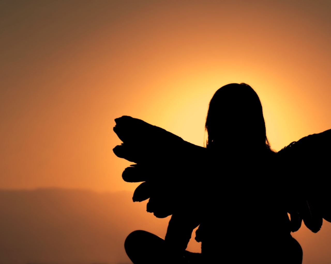 Силуэт девушки с крыльями ангела на фоне заката