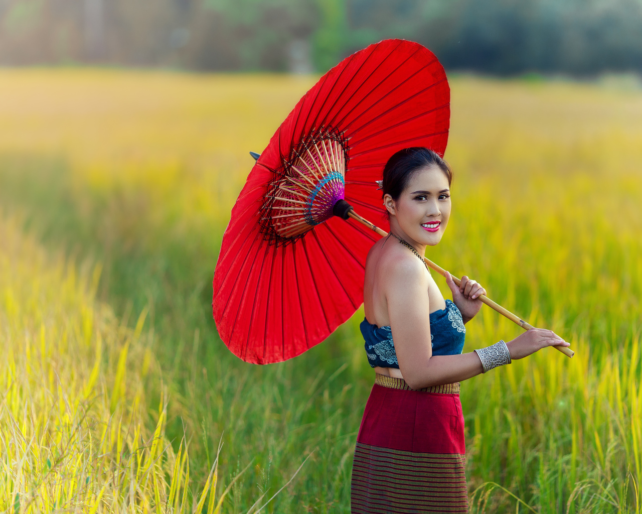 Улыбающаяся девушка азиатка с красным зонтом