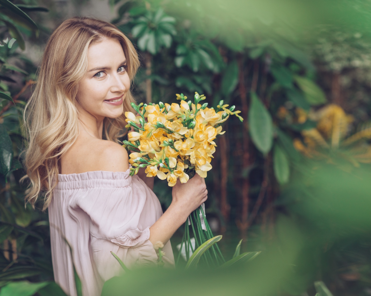 Улыбающаяся блондинка с букетом хризантем в руках
