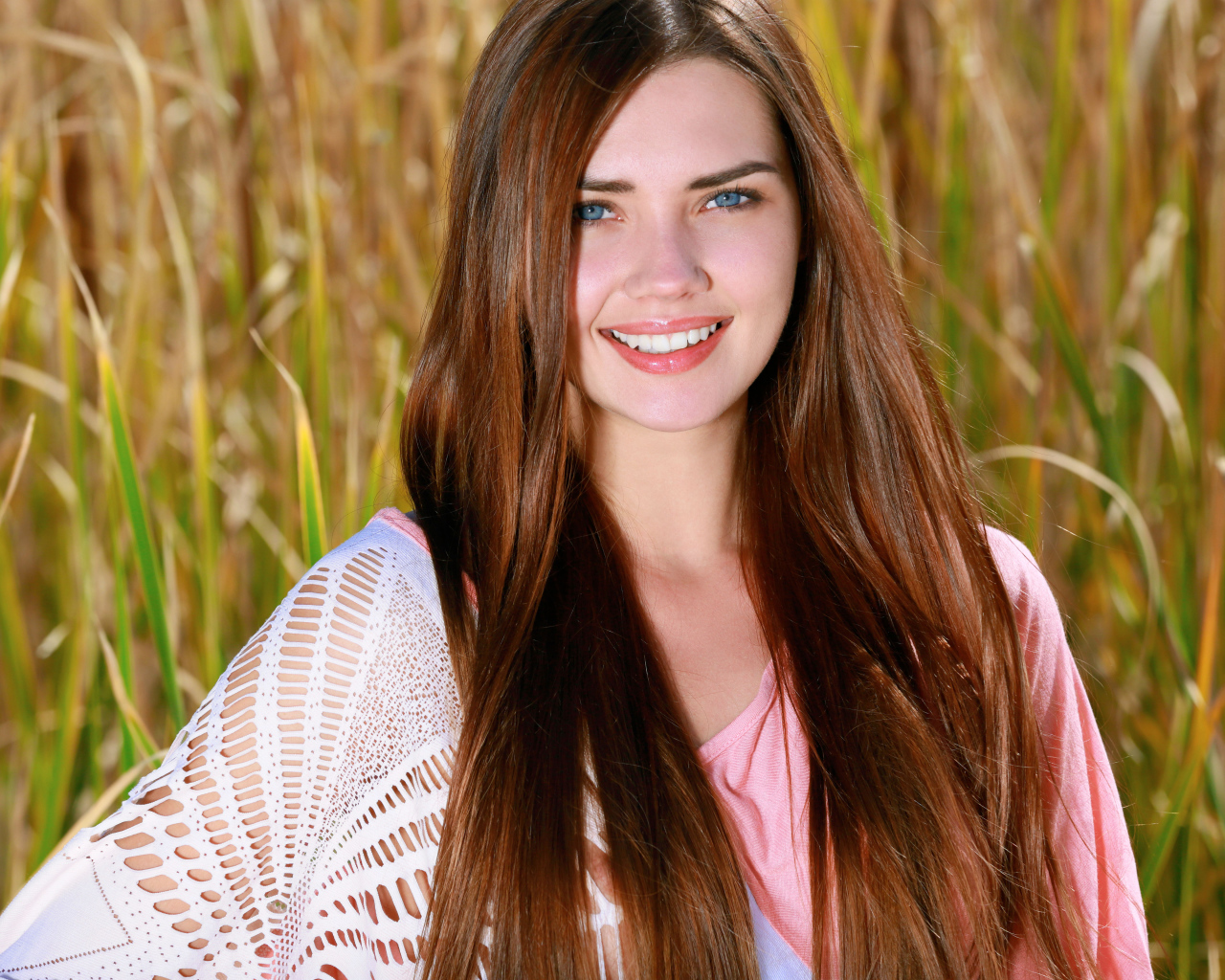 Улыбающаяся голубоглазая шатенка на поле