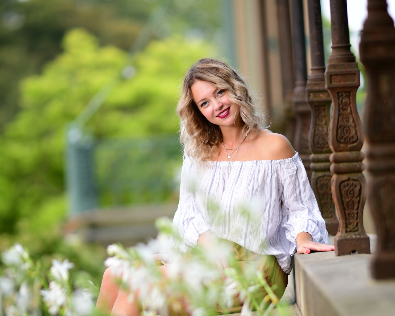 Улыбающаяся девушка сидит на ступенях